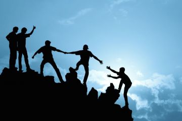 People helping each other up a hill
