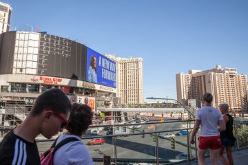 People passing by a billboard promoting Kamala Harris during the 2024 US presidential campaign on Las Vegas Strip