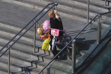 Person laden with children's presents, Westfield shopping centre