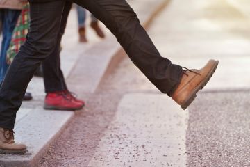 Person stepping onto pedestrian crossing Person stepping onto pedestrian crossing