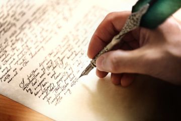 Person writing letter with metal quill Person writing letter with metal quill