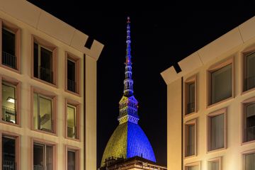 photo of mole antonelliana, monument of Turin, with the colors of the ukrainian flag. the flag was projected to demonstrate the solidity of the city to the ukraine invaded by russia.