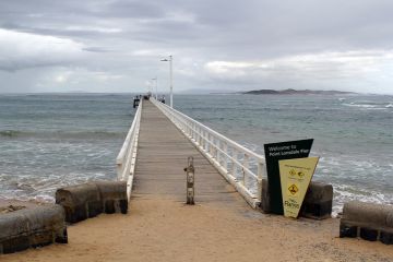 Point Lonsdale, Victoria, Australia - April 16, 2024 Point Lonsdale Pier with the ocean, beach and an overcast sky