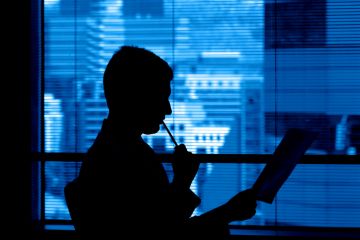 A reviewer in a corporate office ponders a manuscript A reviewer in a corporate office ponders a manuscript