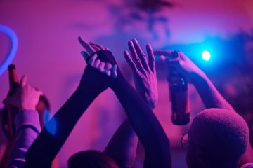 Raised arms of young friends dancing