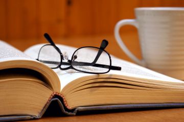 Reading glasses lying on open book Reading glasses lying on open book