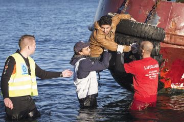 Lifeguard rescuing a man from a boat