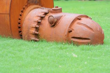 A rusty iron robot sculpture at the University of Alabama, sybolising university obsolescence