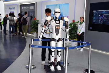 Young Asian man with robot