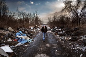 Man walks through a rubbish strewn road Man walks through a rubbish strewn road