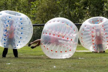 Saint John, New Brunswick, Canada - August 26, 2017 Events at the Dragon Boat Festival. People play bubble soccer. Saint John, New Brunswick, Canada - August 26, 2017 Events at the Dragon Boat Festival. People play bubble soccer.