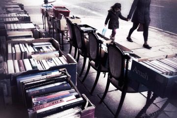 People walk past second hand books for sale