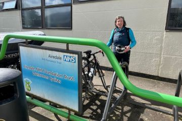 Shunna Burke after cycling to hospital , stood by NHS sign