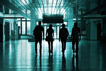Silhouettes of students walking in university hallway Silhouettes of students walking in university hallway