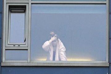 A student at the window in a university halls of residence