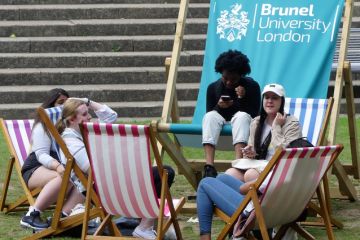 Students relaxing on deck chairs at Brunel University London Students relaxing on deck chairs at Brunel University London