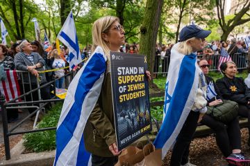 People attend a Holocaust memorial ceremony held a block away from Columbia University as protests both for and against Israel continue at area universities and colleges on 6 May, 2024 in New York City. 