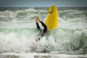 Surfer having a wipeout, too illustrate that universities should not be too quick to torpedo the idea of an overseas student levy, in case they end up with something worse.