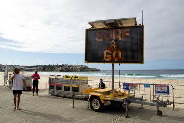 Sydney, NSW, Australia, April 28, 2020. Sign indicating that the beach is open again for surfing but not lingering