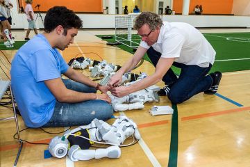 Student and teacher fixing robots, as an illustration of how student support is set to become ‘primary focus’ amid AI rise.