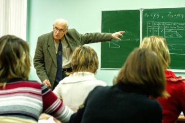 An elderly professor teaches from the blackboard An elderly professor teaches from the blackboard