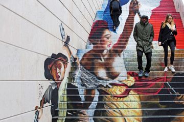 A couple walking down steps with graffiti in the background