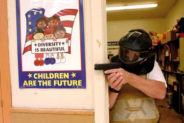 Police training exercise with gun and diversity poster
