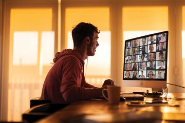 Man looking at computer screen with video conferencing
