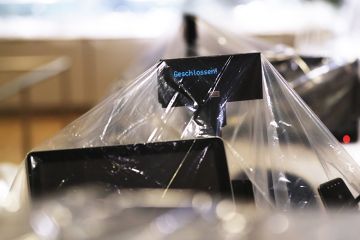 Plastic covers wrap around check-out counters in the closed restaurant and dining area inside a store in Berlin, Germany, on Wednesday, May 20, 2020