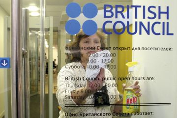 A woman cleans a door of the British Council office in St Petersburg