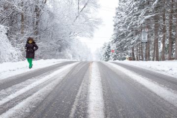 Toronto Ontario Canada Woman walking down a rural road covered with snow