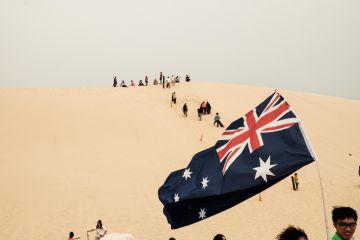 Tourists sliding sand board down the sand dunes in Port Stephen, Australia