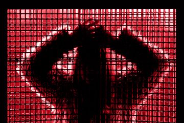 Silhouette of young woman behind window