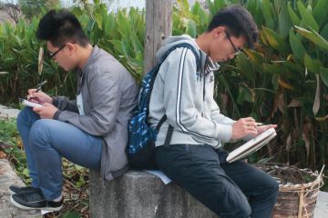 Two male art students sketching back-to-back, Hongcun village, Anhui, China Two male art students sketching back-to-back, Hongcun village, Anhui, China