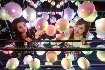 Two women look at pollen robots in Japan Two women look at pollen robots in Japan