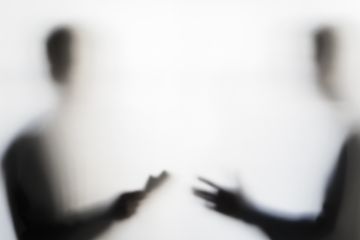 Two men negotiating behind curtain