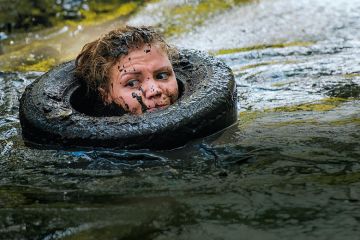 Woman in tyre in muddy river