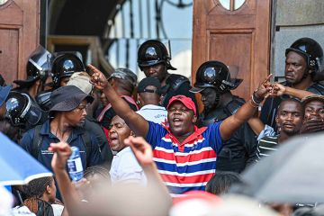 Chairperson of the University of the Free State student council, Pfarelo Maphangula, addresses students in front of the main building, 11 February 2025, South Africa. The group is demanding that students who owe money should be allowed to attend classes.