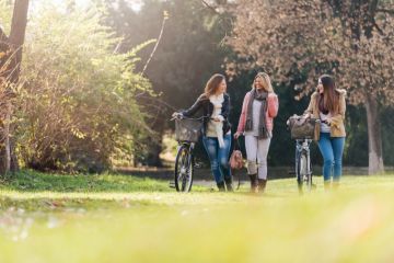 university students on green campus with bicycles to represent sustainability