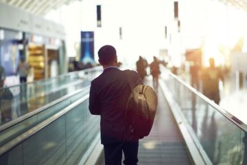 person walking on airport escalator