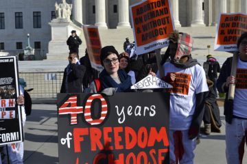 Washington D.C., USA - January 22, 2015; A Young woman holds a pro-choice sign at the U.S. Supreme Court in Washington D.C.