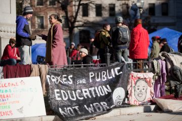 Washington DC, USA - December 10, 2011 Protest signs are hanging on a fence as members of the Occupy Movement gather in DC's McPherson Square to discuss and educate others.