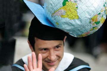 Justin Ginnetti, a graduate of the Fletcher School of Law and Diplomacy, wearing n inflatable globe hat to illustrate Supercharge the goals