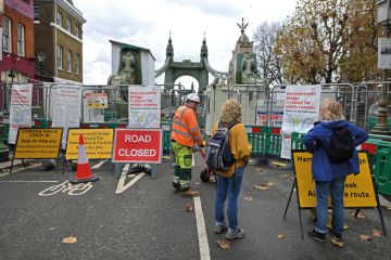 Members of the public looking at the closed fence to the old Hammersmith Bridge over the River Thames in west London Members of the public looking at the closed fence to the old Hammersmith Bridge over the River Thames in west London to illustrate massive closures