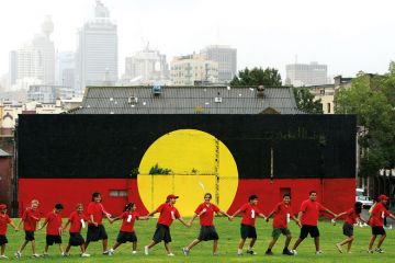 Students from Our Lady of Mount Carmel join hands to celebrate after watching the live television broadcast from the Australian Parliament in Canberra as a metaphor for Indigenous reconciliation ‘can get in way of act ion’ for universities