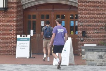 Students wearing face masks enter a makeshift COVID-19 testing area at Georgetown University 