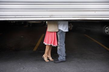 Couple behind garage shutters to illustrate Relationships register or full ban is ‘catch-22’ for universities