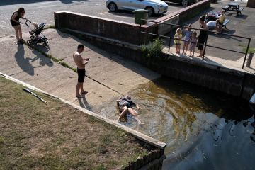 A young woman lies in shallow water after slipping on a boating ramp in Beccles Quay as a metaphor for progress on gender parity in research ‘set back a year’ by Covid