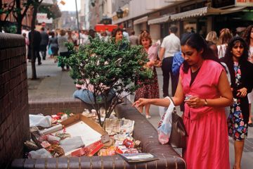 A lady drops a piece of litter on a growing pile of rubbish to illustrate ‘Treasury win’ throws HE funding worries on next government’s pile
