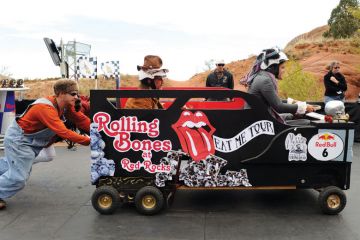 Man pushes person in car race_as a metaphor for UK universities becoming increasingly reliant on agents for the recruitment of European Union students.